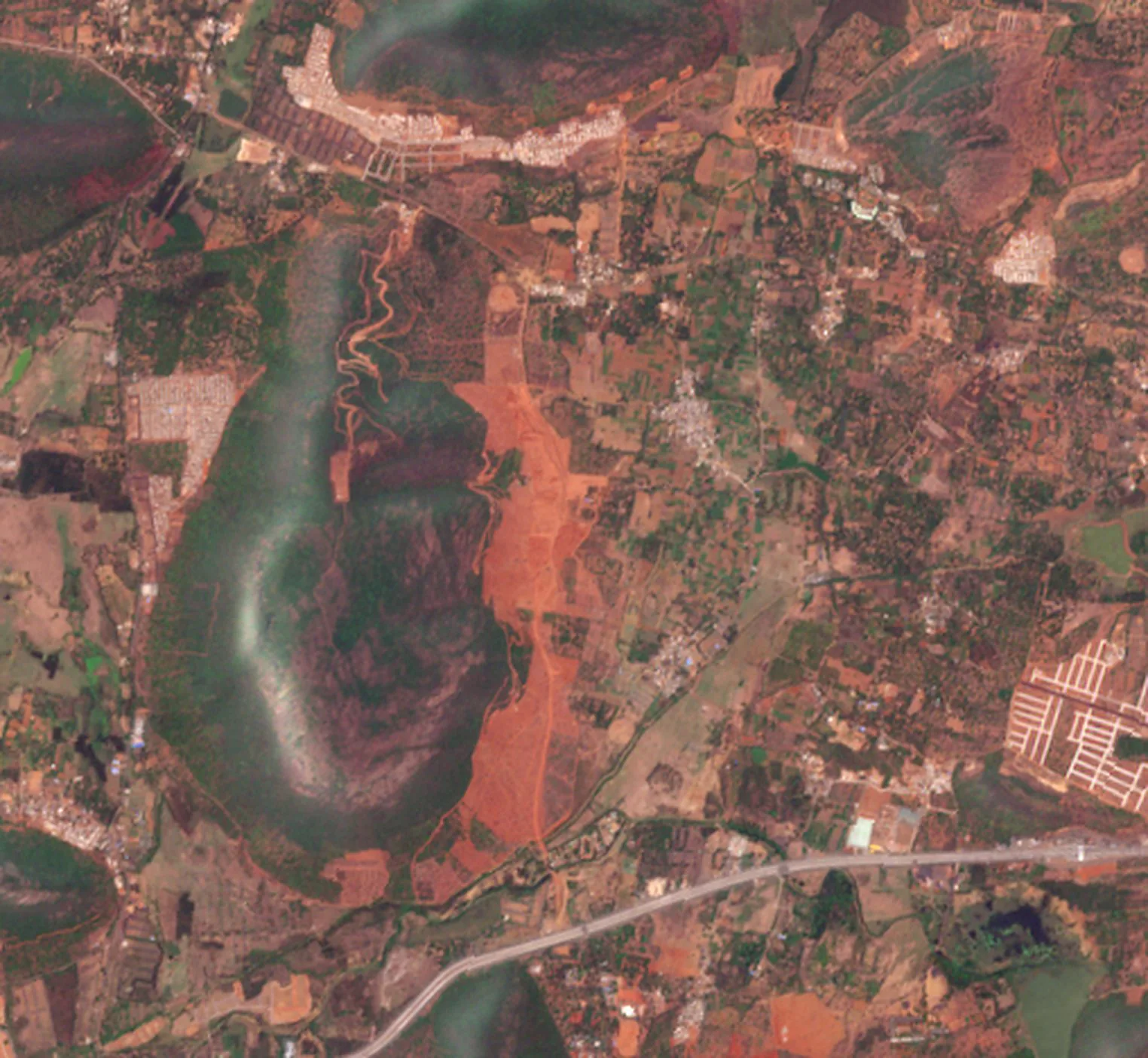 Tarluvada on 16 April 2026, with large areas of bare red earth around the foot of a hill.